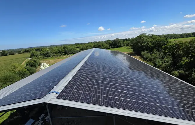 Vue drone d'un hangar agricole ouvert dont la toiture est couverte de panneaux